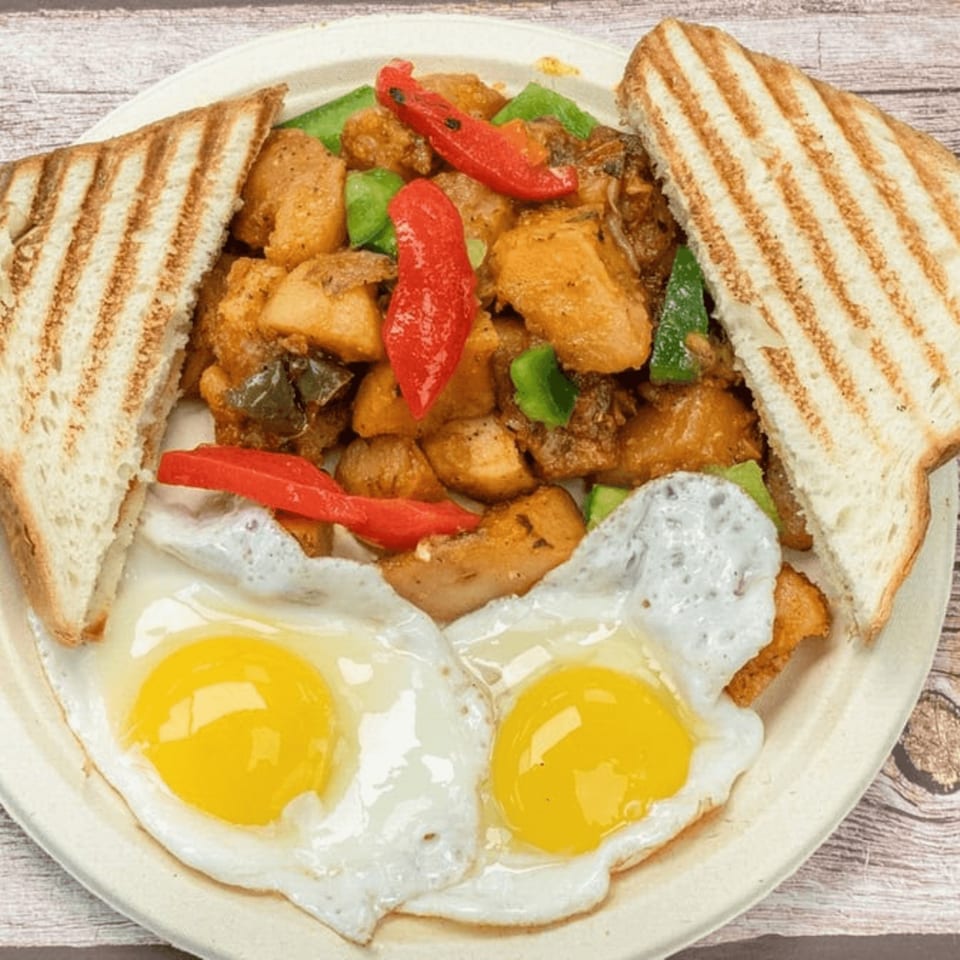 Tony's Panini Grill Hillside breakfast plate with home fries, two fried eggs, and grilled toast.