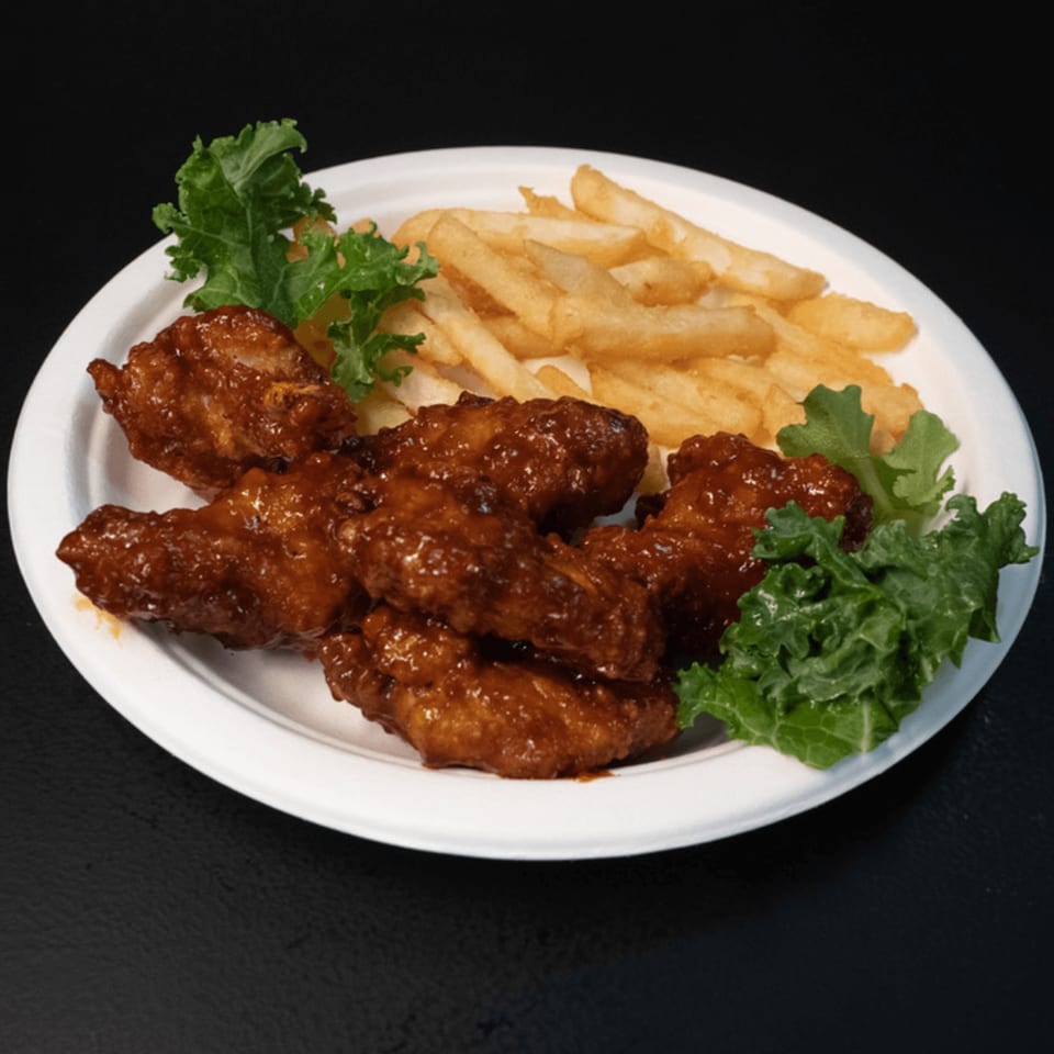 Tony's Panini Grill Hillside's chicken wings with fries and kale on a white plate.